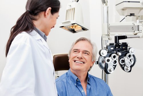 Smiling patient consulting with ophthalmologist during eye exam