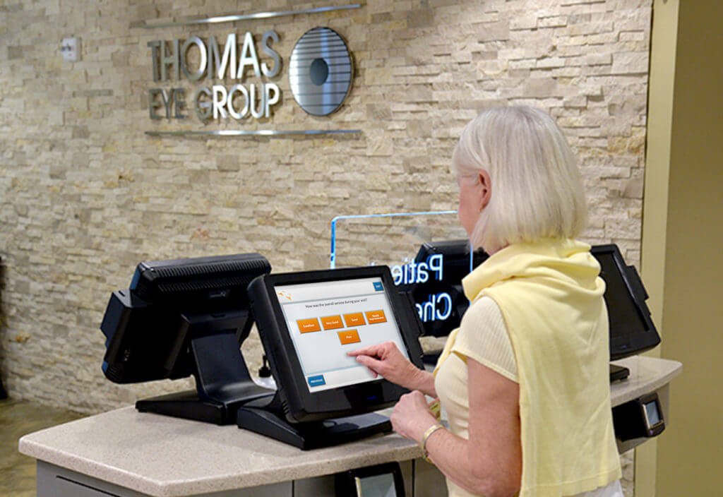 Woman using the Clearwave self check-in kiosk at Thomas Eye Group