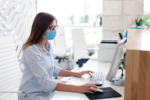 Woman using patient check-in system at desk