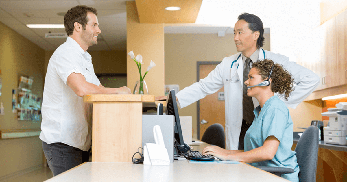 Staff and Patient at Check-In Desk